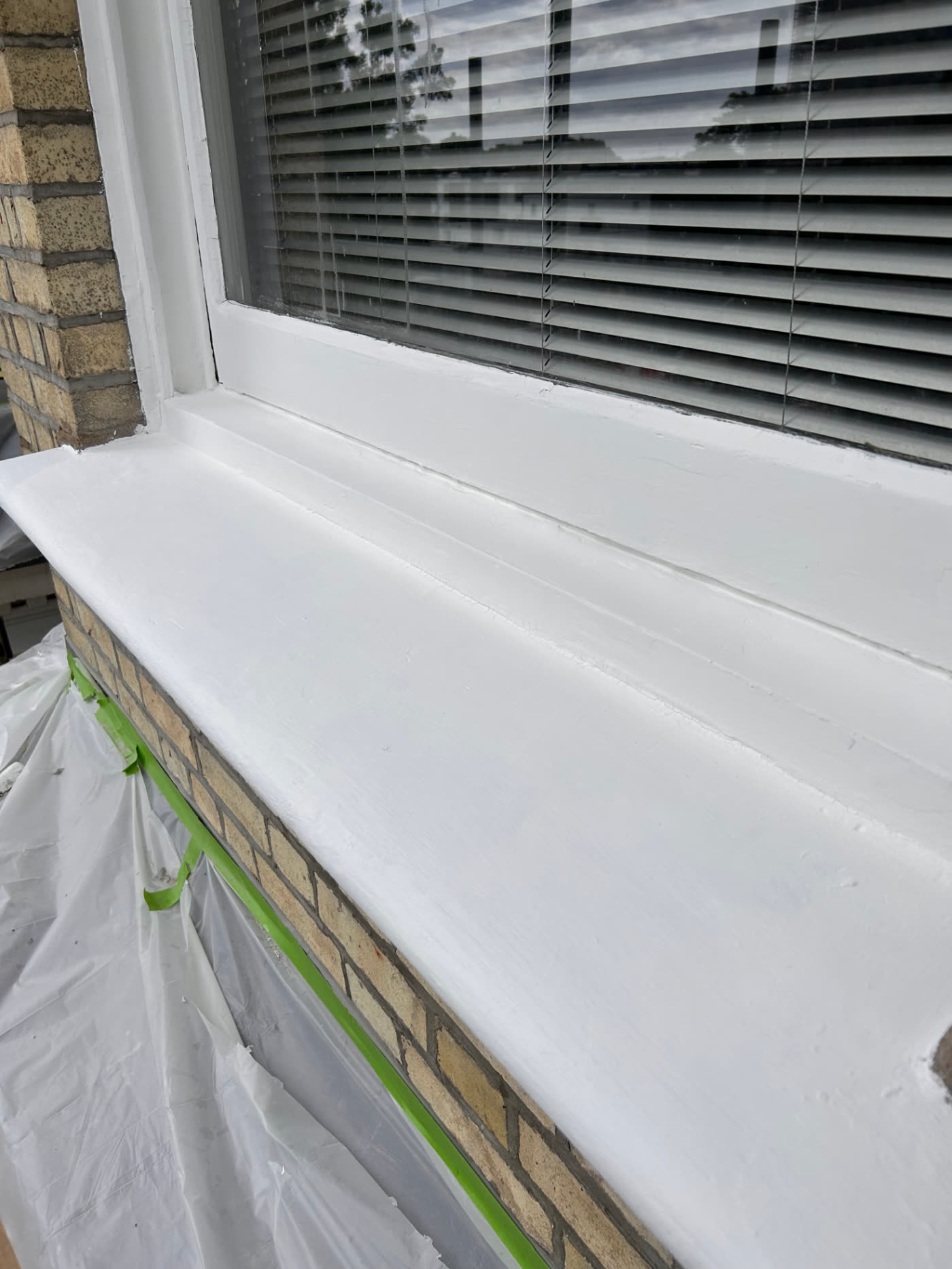 After photo — Maida Vale timber window and sill restoration. Rotten, flaking timber on a window frame and sill repaired, prepared and repainted in white.